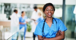 A person in blue scrubs with stethoscope around her neck Description automatically generated