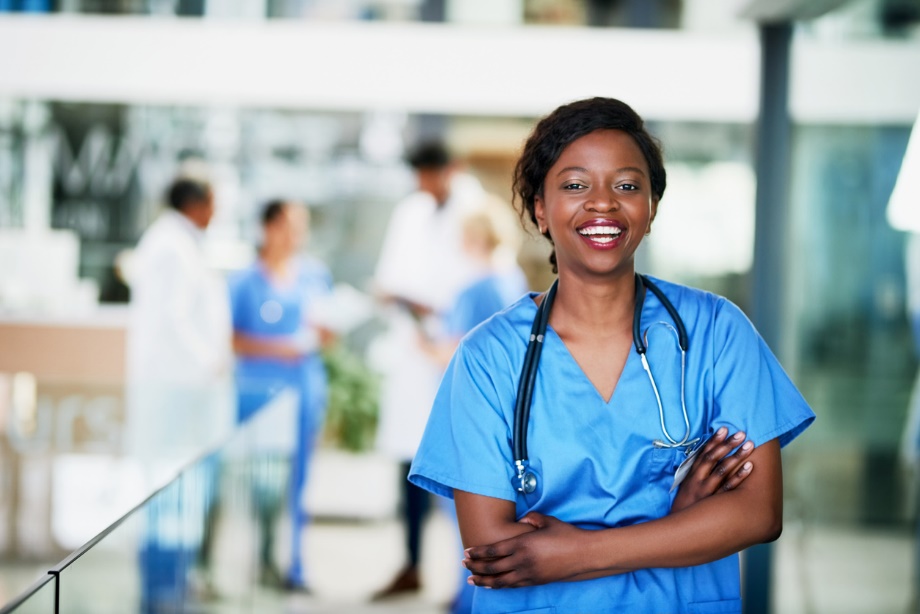 A person in blue scrubs with stethoscope around her neck
